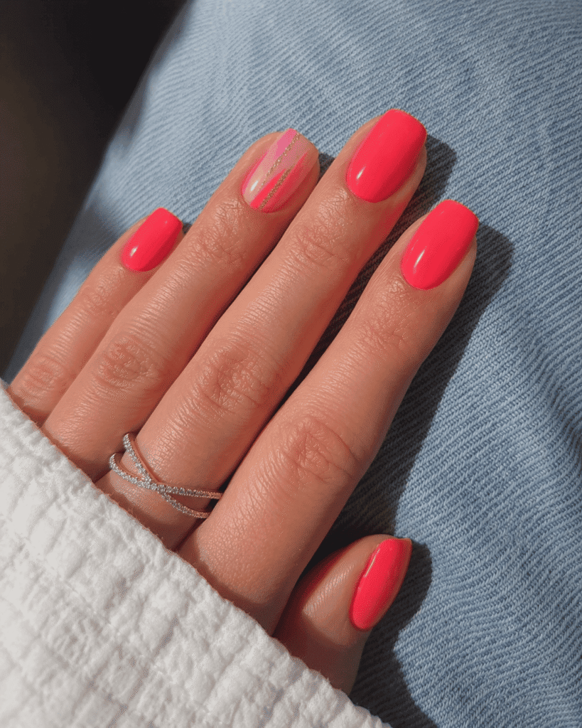 Bright neon pink summer nails with glossy square-shaped manicure, featuring a stylish accent nail with pink stripes and delicate gold line details, paired with silver rings and casual denim background.