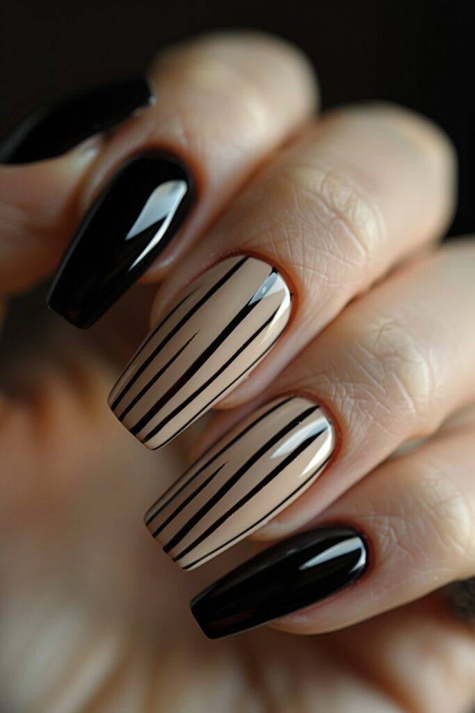 Elegant square-shaped nails featuring glossy black polish and nude accent nails with thin black stripe details, creating a sophisticated minimalist nail art design.