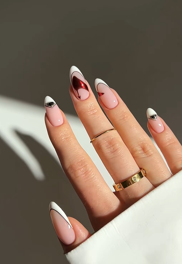 Elegant almond nails with glossy nude pink polish, white French tips, and metallic chrome accent details creating a modern minimalist manicure aesthetic.