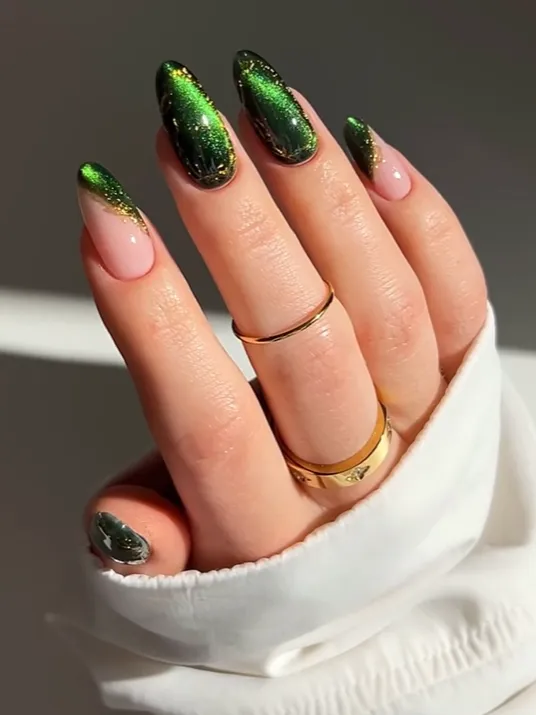 Emerald Chrome French Nails Emerald green chrome French tip nails with glitter accents on almond-shaped acrylic nails, featuring glossy metallic nail art design and elegant luxury manicure inspiration.