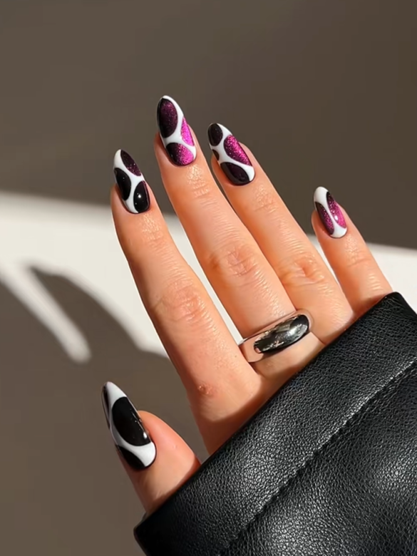 Bold abstract swirl nails with black white and glitter pink patterns on almond-shaped acrylic nails for a trendy modern manicure look.